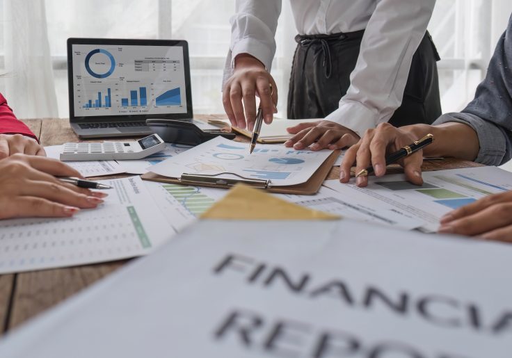 Business People Meeting using laptop computer,calculator,notebook,stock market chart paper for analysis Plans to improve quality next month. Conference Discussion Corporate Concept